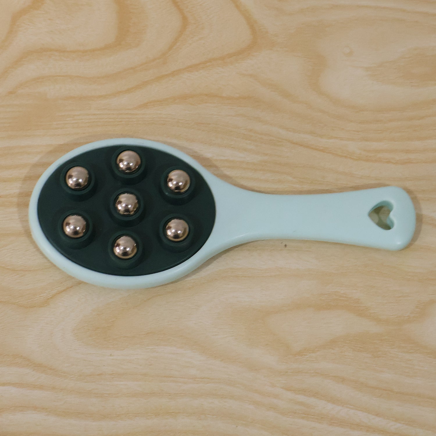 Handheld roller ball massager in retail packaging.